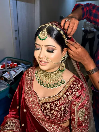 Final touches on the dupatta for this bride. Her smokey eye makeup and velvet lehenga create a rich, luxurious look.