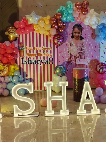The light-up marquee letters are a central part of the decor, providing great lighting and a personalized focus for the 'Candyland' birthday stage.