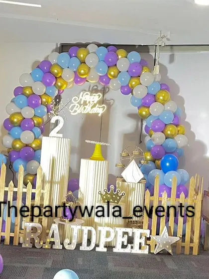 A colorful balloon arch with purple, blue, and gold balloons, perfect for a 2nd birthday.
