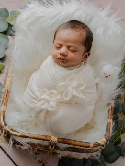 An example of a rustic, natural setup using a wicker basket, white fur, and eucalyptus leaves. This style focuses on texture and earthy tones for a timeless look.