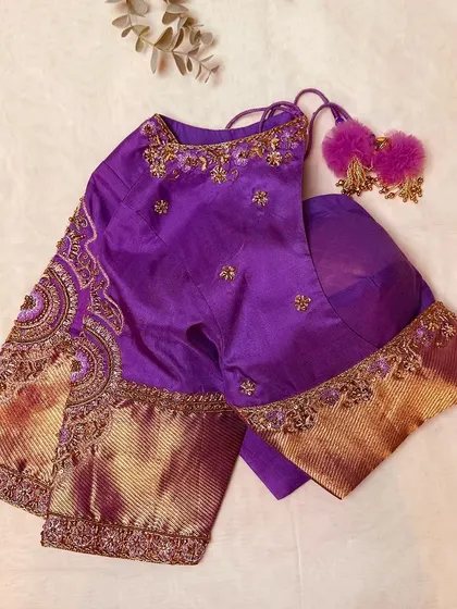 A purple silk blouse with intricate gold embroidery and a heavy Kanjeevaram border on the sleeves.