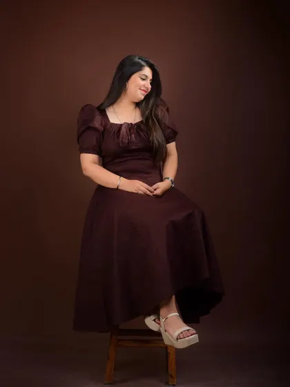 A seated portrait in a modern dress. This pose is elegant and modest, showcasing a quiet confidence.