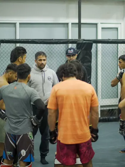 The team huddles around the coaches before a sparring session. This is where game plans are discussed and instructions are given. We train as a single, cohesive unit.