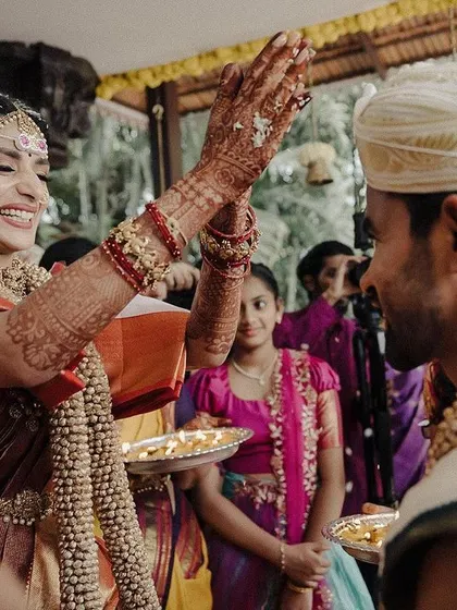 A candid moment of a bride showering her groom with sacred rice, her face lit up with a brilliant smile. These are the authentic, in-between moments during a ceremony that tell the true story of the day.
