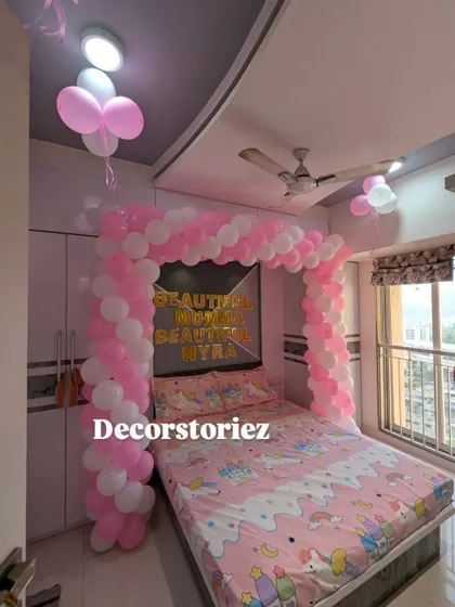 Extending the celebration to the bedroom with a lovely pink and white balloon arch over the bed, creating a sweet and cozy atmosphere for the new baby.