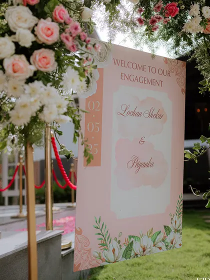 A welcome sign for an engagement, featuring a soft pink watercolor design and elegant script.