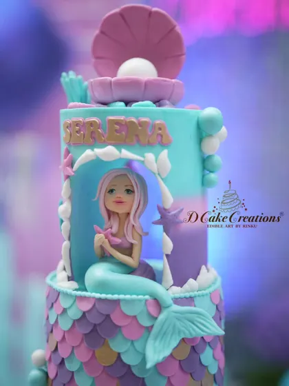 A close-up of our enchanting mermaid cake. This shot highlights the detailed, hand-sculpted mermaid figurine and the edible pearl inside a seashell topper.