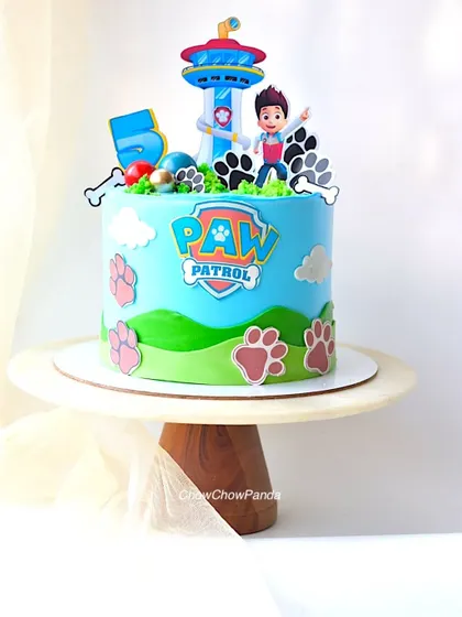 A straight-on view of the Paw Patrol cake, showing Ryder and the lookout tower on top.