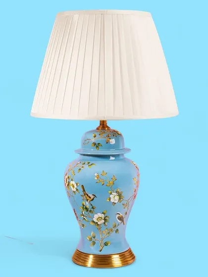A lovely sky blue base with painted birds and flowers gives this lamp a light and airy feel. It's a wonderful piece for bringing a touch of nature-inspired beauty indoors.