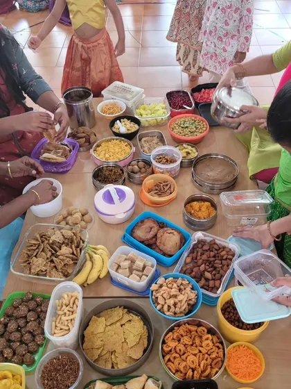 A table laden with delicious snacks for our Dussehra community potluck. Sharing food is a wonderful way to celebrate together.