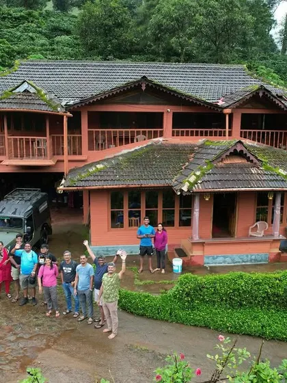 A group photo in front of a beautiful, large homestay in the middle of a coffee estate. The perfect base for our adventures.