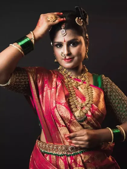 A client looking radiant in a traditional pink and green silk saree with a heavily embroidered blouse.