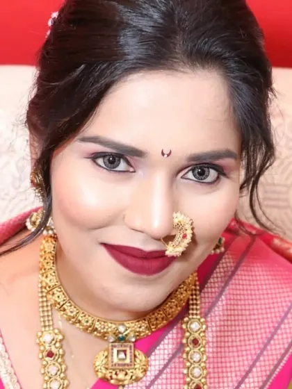 A close-up of a stunning Maharashtrian bride. She is wearing a traditional choker and a longer necklace, paired with the iconic crescent-shaped nath.