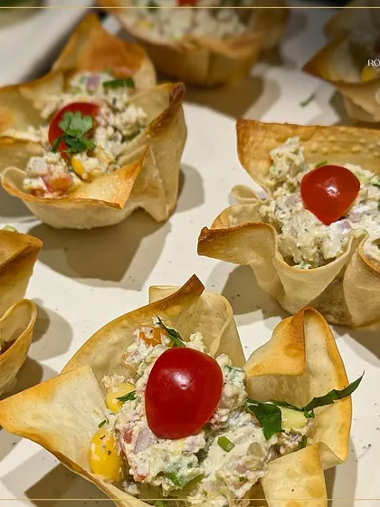 These crispy wonton cups are filled with a creamy chicken and vegetable salad. They offer a delightful crunch and a savory filling in one perfect bite.