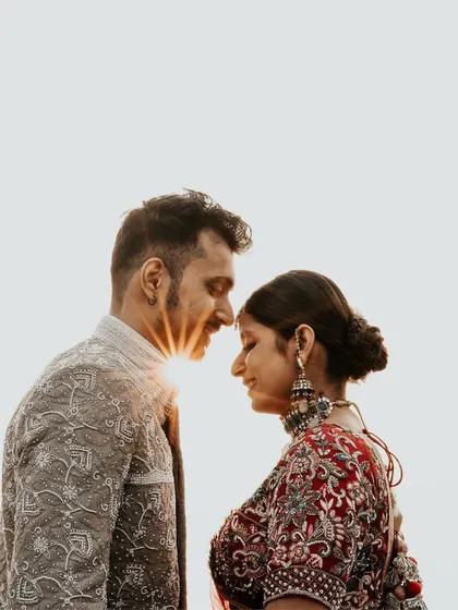 A creative sun-flare shot. We positioned the couple so the setting sun creates a perfect starburst effect between them, resulting in a unique and magical golden-hour portrait.