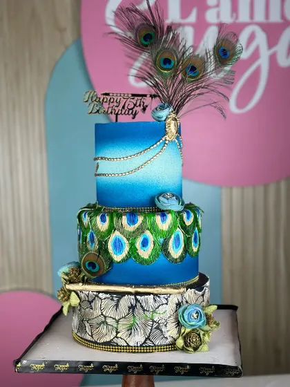 Crafted with love for a special 75th birthday. This Krishna-themed cake features vibrant peacock feather details in blue and green, celebrating a lifetime of wisdom and joy.