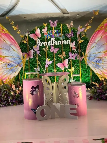 This butterfly theme is a great example of combining different elements for a magical effect. I used a lush green wall, custom butterfly wing props, and themed cake plinths to create an enchanted garden feel.