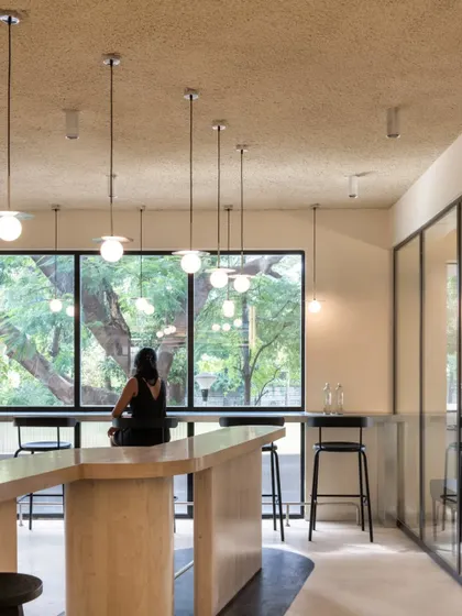 A view across the community table towards the large window, where a customer enjoys a moment of solitude.