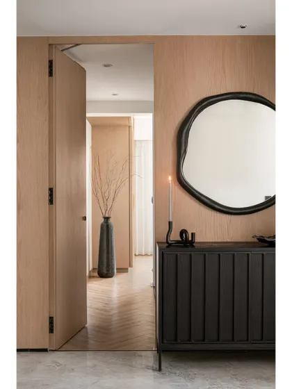 A glimpse from the living area into the master bedroom corridor, showing how natural oak doors and herringbone flooring create a warm and continuous flow throughout the home.