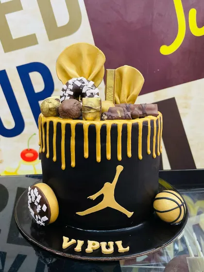 A 2.5kg basketball-themed cake with the iconic Jordan logo, a golden drip, and donut accents.
