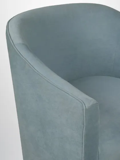 A detail of the armchair's arm, showing the soft fabric and the clean, contemporary lines.