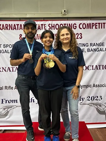 A proud family moment on the winner's podium. We recognize that support from family and coaches is crucial to a shooter's success.