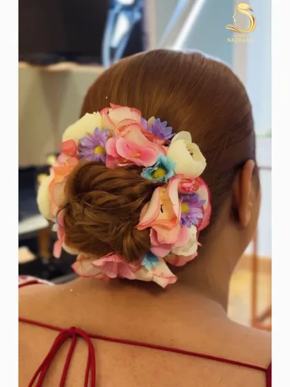 A close-up of the multi-colored floral bun, showcasing the beautiful arrangement of flowers.