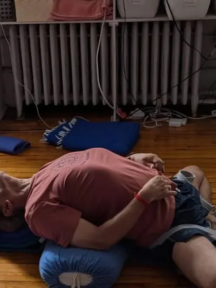 A restorative pose, Supta Baddha Konasana (Reclining Bound Angle Pose) supported by a bolster. This posture helps to quiet the mind and release tension in the hips and groin.