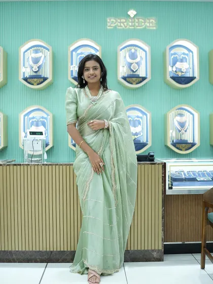 Sonu looking elegant in a pastel green saree with a puff-sleeve blouse during a jewelry store visit.