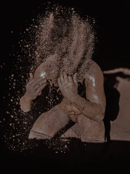 Two highly artistic shots of a wrestler with soil exploding around his face. These images capture the dynamic and elemental nature of wrestling in the mud pit.