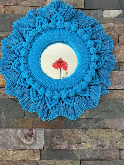 For a bold pop of color, this macrame mirror in bright turquoise is a perfect choice. It's a statement piece that brings energy and a boho vibe to any room.