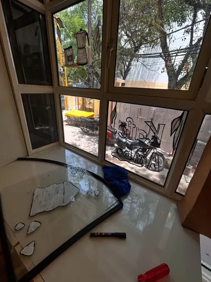 A view from my workspace while painting the glass panels. You can see the illustrations of a moka pot and a motorcycle coming to life, ready to be installed at the cafe.
