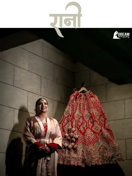 A creative "getting ready" shot of bride Ahana looking up at her magnificent wedding lehenga before putting it on.