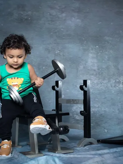 This toddler is showing off his strength, lifting two dumbbells at once. A future bodybuilder in the making.