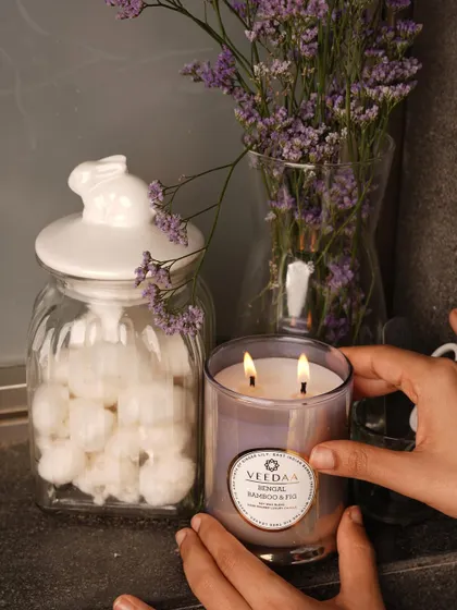A gentle hand adjusting our Bengal Bamboo & Fig candle. It's these little touches that make a house feel like a home, and our fragrances are designed to be a part of those moments.