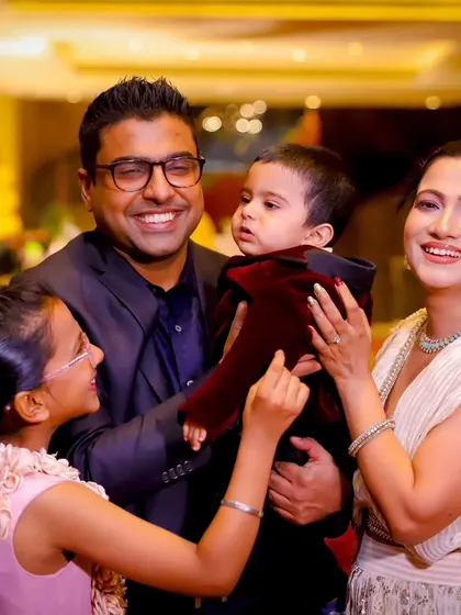 A happy family of four celebrating a milestone. We make sure to include siblings in the photos, capturing their special bond.