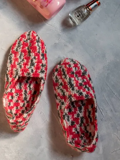 A top-down view of our red, grey, and white crochet house slippers. These are easy to slip on and are a perfect cozy accessory for winter.