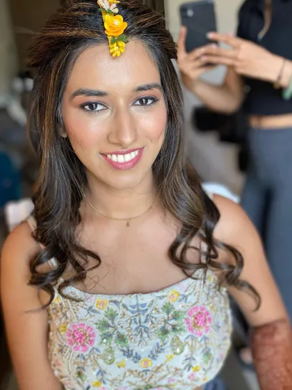 A smiling portrait of the bride, her makeup looking fresh and radiant for her daytime Haldi event.