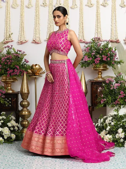 The side profile of our fuchsia Bandhani lehenga, showing how the dupatta can be draped to create a dramatic and elegant effect.