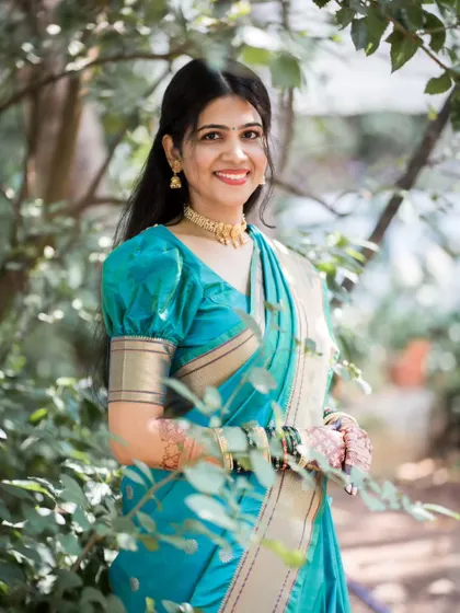 A lovely portrait of the bride framed by green leaves, creating a natural and fresh look for her Haldi day photos.