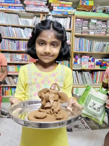 A young girl proudly displays the Ganesha idol she crafted herself. These workshops are not just about art; they are about creating lasting memories and celebrating traditions together.