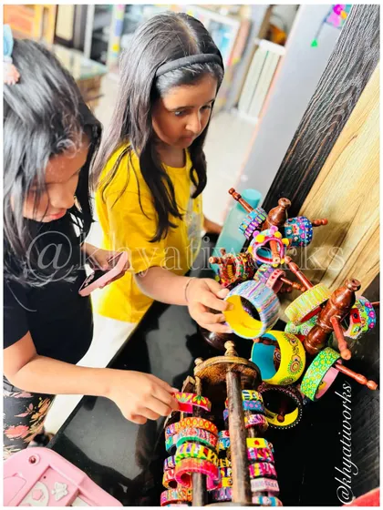 Two little customers carefully choosing their favorite bangles from the display stand. It's so fun to see which colors and patterns they are drawn to.