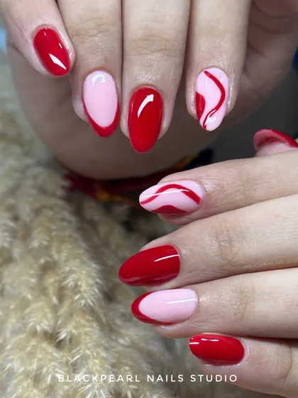 A playful mix of hot red and soft pink. This design features solid colors, a modern French tip, and a hand-painted swirl accent nail for a bold and fun look.