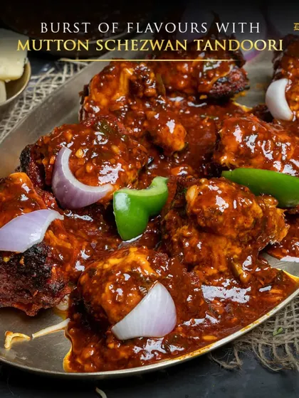 A burst of flavours with Mutton Schezwan Tandoori. This image captures the glossy, rich texture of the Schezwan sauce clinging to every piece of mutton. It's a dish that delivers a powerful kick of spice and flavour.
