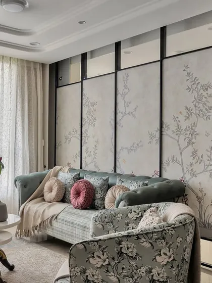 This living area is styled for comfort and elegance. The floral-patterned seating, layered throws, and soft lighting create a cozy atmosphere perfect for relaxing or hosting guests.