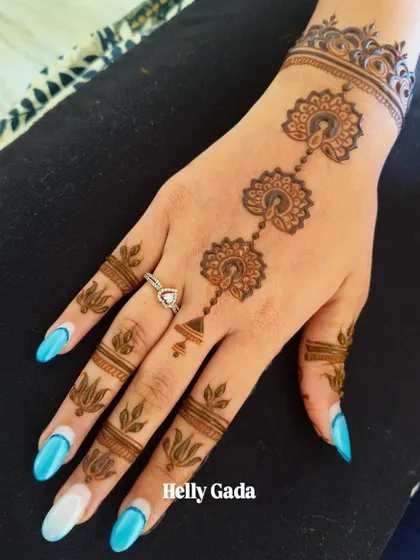 A beautiful minimalist design for a bride-to-be. This pattern features a delicate chain of peacock-inspired motifs running down the back of the hand, with simple leafy details on the fingers.