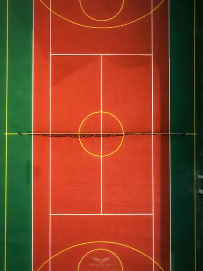 A perfectly symmetrical top-down shot of a tennis court, highlighting our eye for graphic compositions and detail in capturing sports amenities.