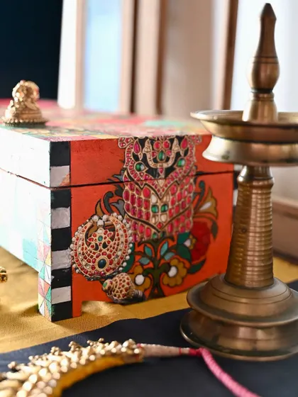 A side view of the box, highlighting the detailed painting of traditional Indian jewelry. These small touches add layers of meaning and beauty to the piece.