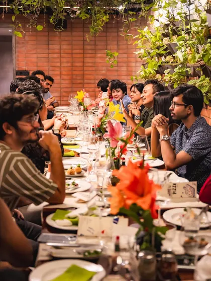 A long shot of our community table during the wine tasting event, filled with engaged and happy guests.
