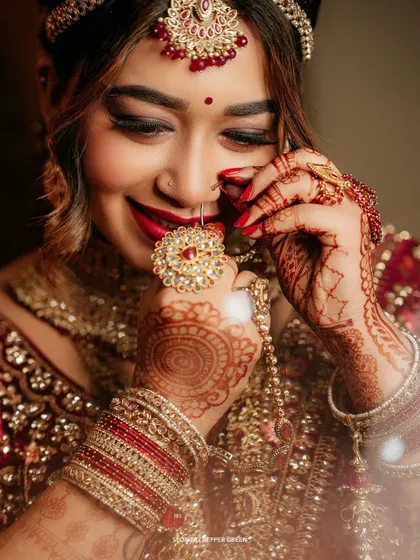 A close-up of bride Reshma's hands, showcasing her intricate henna and stunning ring. Detail shots like this add richness and texture to the wedding film.